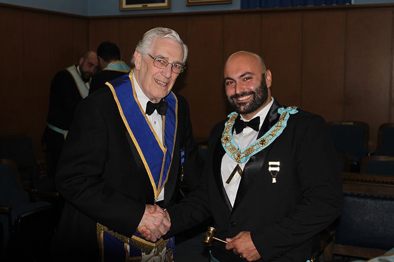 Two members shaking hands at a Lodge installation